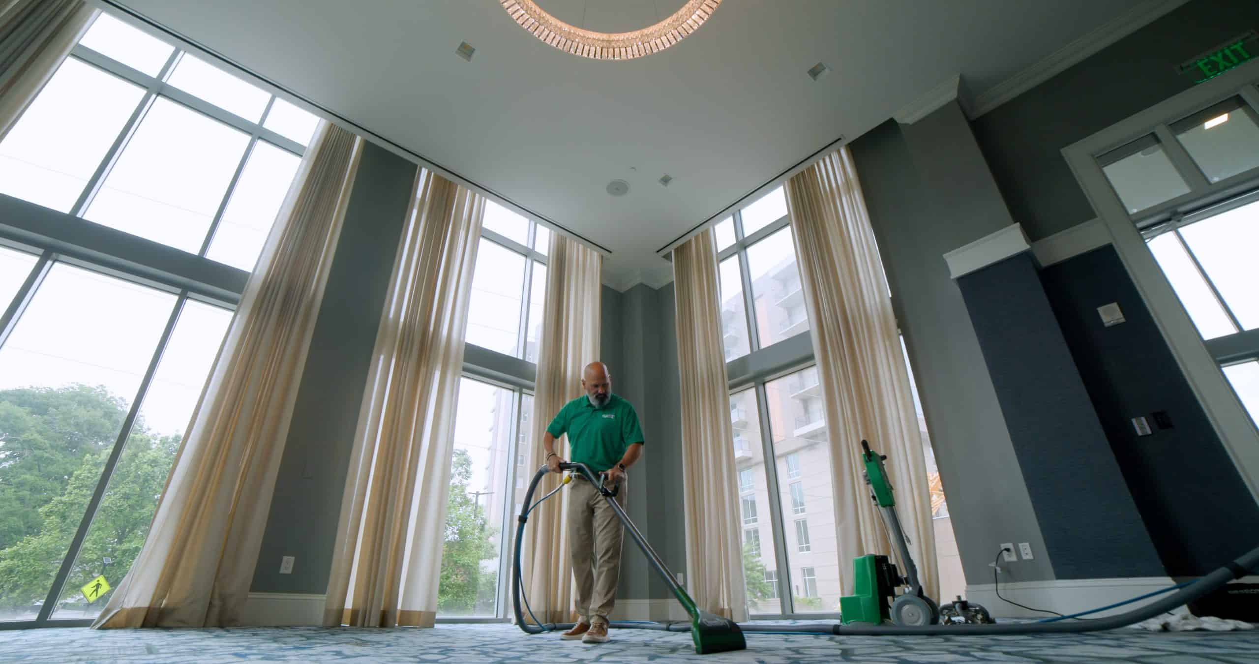 Commercial carpet cleaning technician cleaning a large hotel ballroom