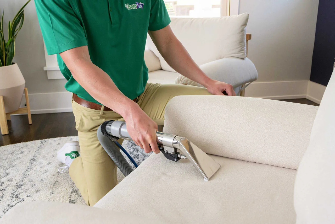 Quick-Dry technician cleaning a beige sofa in a Grayslake home